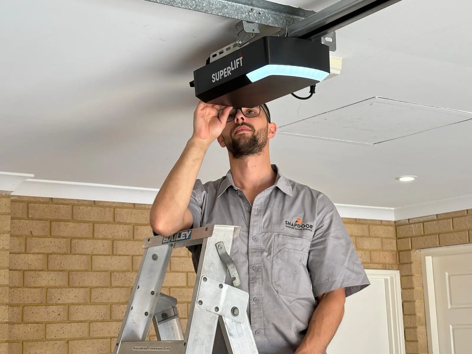 SnapDoor technician installing a Superlift garage door motor