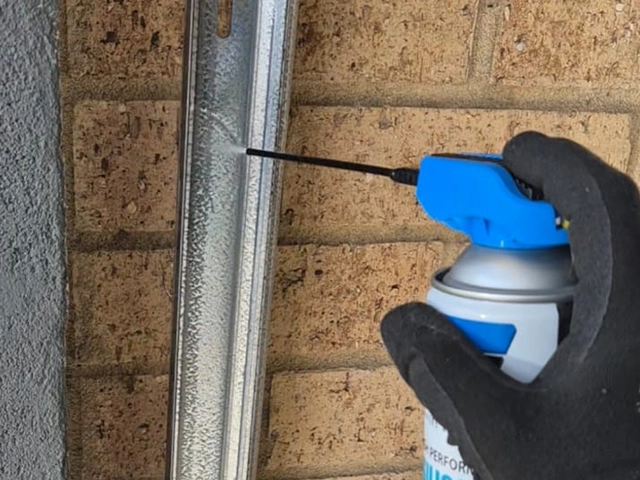 Technician lubricating garage door rollers